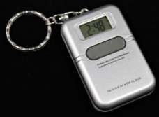 A keychain device with a digital display for the time and a button