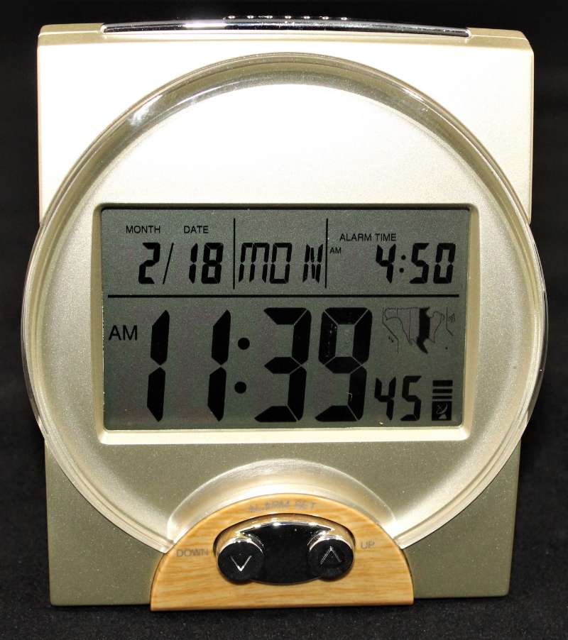 Desktop clock with a digital display for the time, month, day, weekday, and alarm time. 